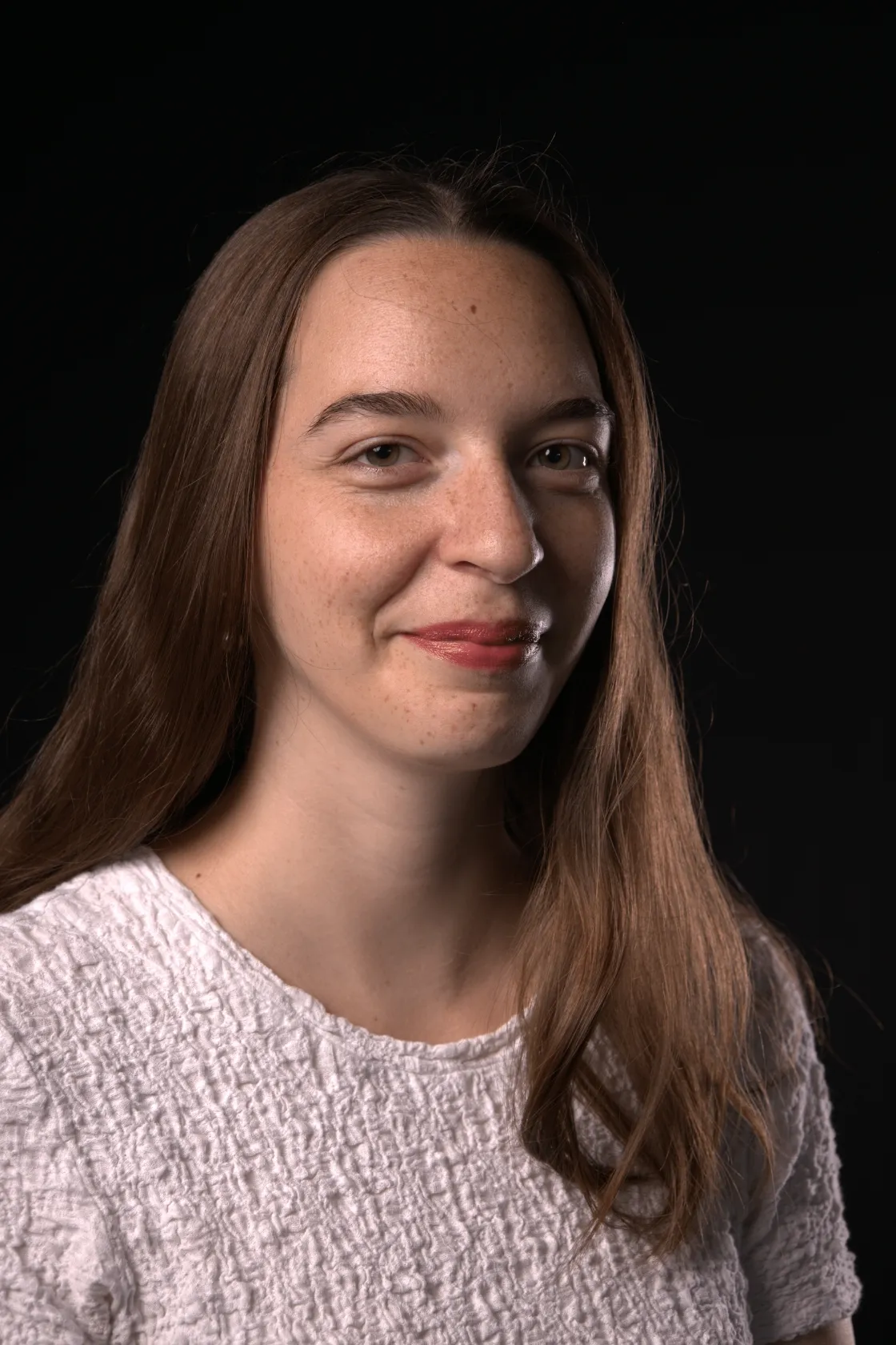 Chloé Wahl, agente en information documentaire avec 2 ans d'expérience en train de lire un livre à l'envers, photo sur fond noir