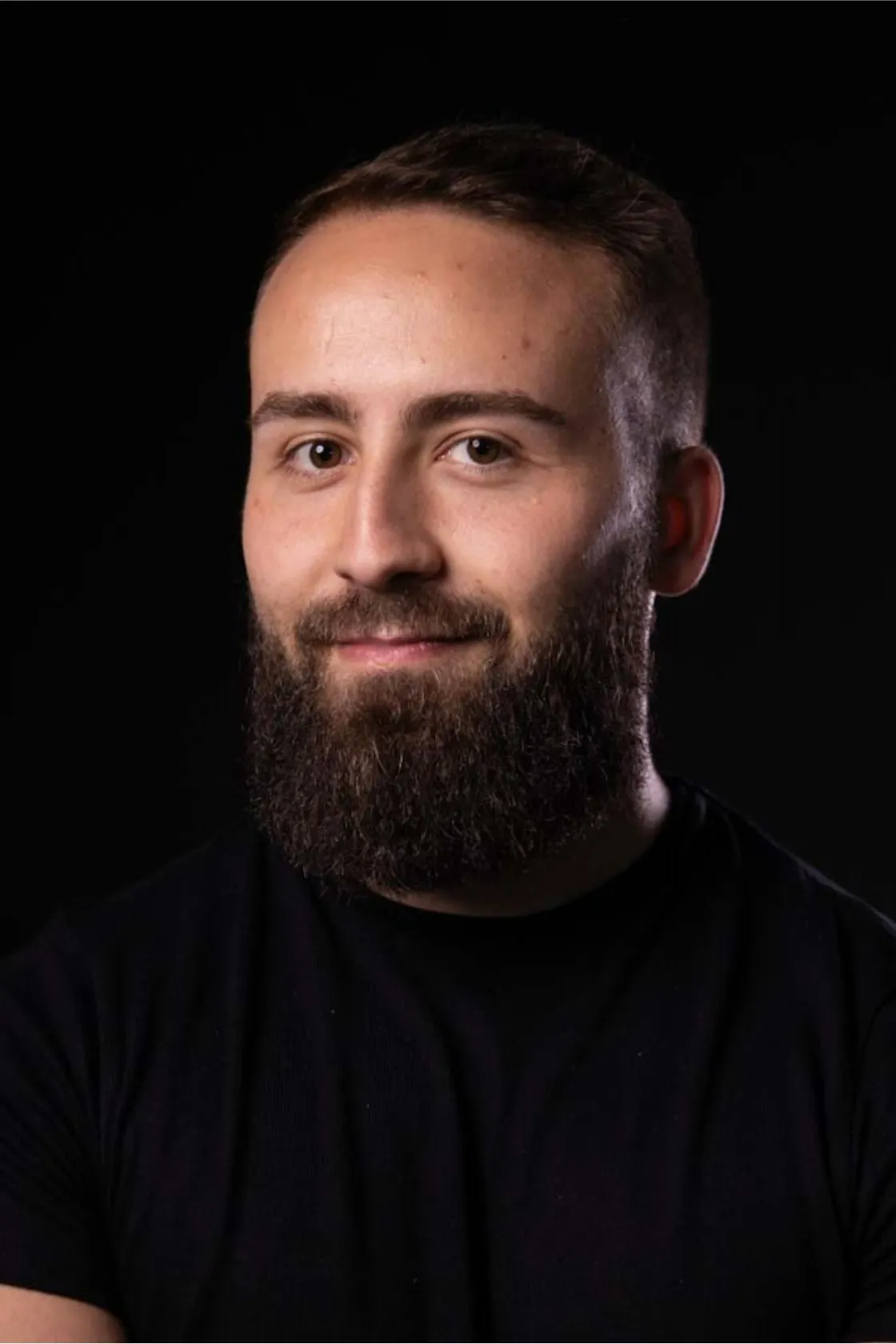 Marco Silva Magalhaes Ferreira, Assistant administratif avec 2 ans d'exp&eacute;rience, photo sur fond noir. Marco a l'air s&eacute;rieux et tient une plante dans sa main