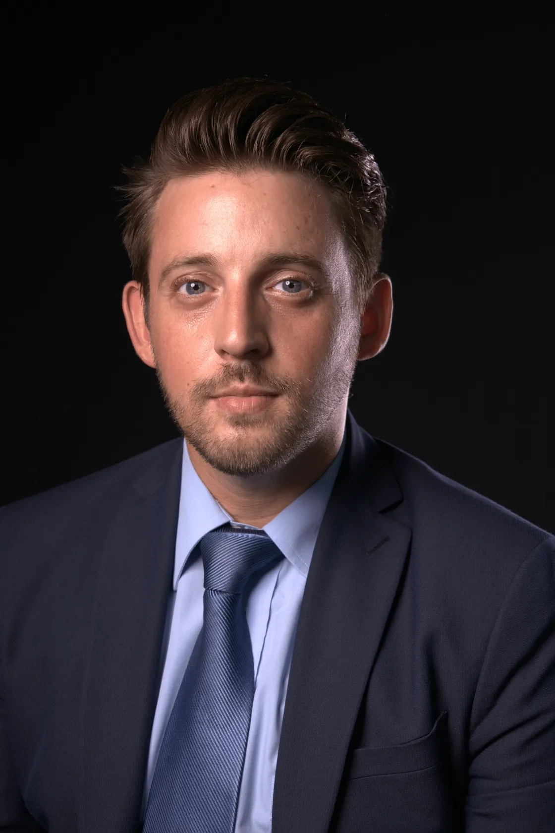 Pierrick Valdes-Top, Assistant en Ressources Humaines avec 2 ans d'exp&eacute;rience, photo sur fond noir. Pierrick lit le code des obligations suisse.